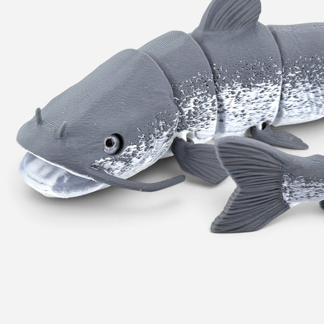 Tidal 3D Printed articulated grey catfish toy made from PLA+ filament with realistic glass eyes and textured detail.